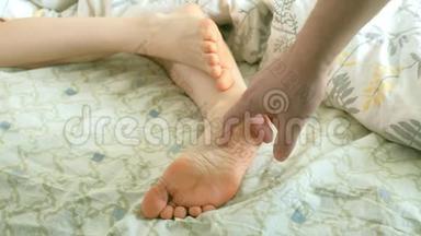一位慈爱的丈夫叫醒了他的妻子，滑稽地挠她的脚